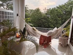 a hammock on the balcony of a house at Dharma Shanti Villa - Private Pool - Peaceful Ubud Escape in Ubud