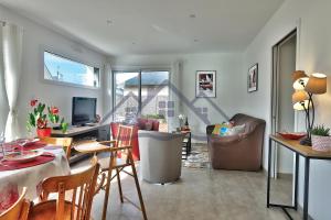 ein Wohnzimmer mit einem Tisch und Stühlen sowie ein Wohnzimmer in der Unterkunft LocaLise - M11 - Ty Gwennili - Maison de plain pied avec terrain entièrement clôturé - Accès plage et centre à pied - Wifi inclus - Draps inclus - Animaux non admis in Le Guilvinec