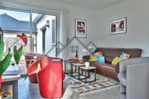 ein Wohnzimmer mit Sofa und Tisch in der Unterkunft LocaLise - M11 - Ty Gwennili - Maison de plain pied avec terrain entièrement clôturé - Accès plage et centre à pied - Wifi inclus - Draps inclus - Animaux non admis in Le Guilvinec