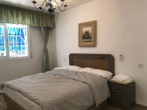 1 dormitorio con cama y ventana en HOLIDAY CHALET BENIDORM, en Benidorm