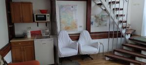 2 sillas blancas en una cocina con un mapa en la pared en Studio Grivita, en Deva