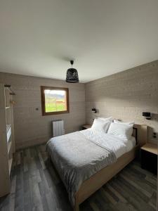 a bedroom with a large bed and a window at Le Chalet Du Castor in Anould