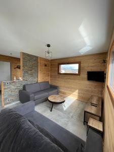 a living room with a couch and a table at Le Chalet Du Castor in Anould