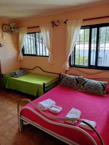 1 dormitorio con 2 camas en una habitación con ventanas en Descanso en casa de familia en Salta