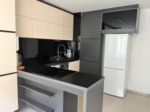 a kitchen with a black counter top and a white refrigerator at Sweet Home Vienna 1 in Vienna