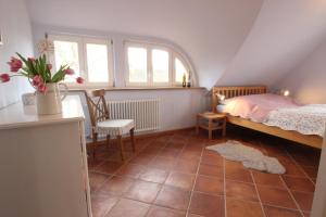 1 dormitorio con 1 cama y 1 silla en el ático en Ferienhaus Leuchtfeuer - Buchungen ab 4 Übernachtungen, en Putgarten