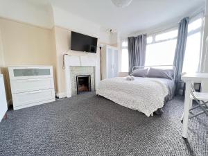 ein Schlafzimmer mit einem Bett und einem Kamin in der Unterkunft Shirley House 4, Guest House, Self Catering, Self Check in with smart locks, use of Fully Equipped Kitchen, close to City Centre, Ideal for Longer Stays, Excellent Transport Links in Southampton