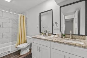 a white bathroom with a toilet and a sink at Evonify Stays - Hyde Park Apartments - UTEXAS in Austin