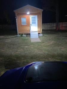 a small shed with a door in a yard at night at Angelas Village 