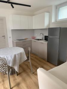a kitchen with a table and a sink and a refrigerator at Appartamento Camelia in Malcesine