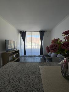 uma sala de estar com um sofá e uma televisão em apartamento Lynch Costero Iquique em Iquique