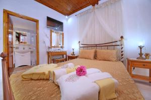 a bedroom with a large bed with towels on it at Vasia's Small Villa in Skopelos Town