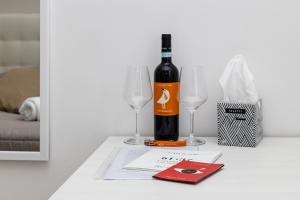泰卡斯的住宿－Vesuvio Casa de Charme，桌子上放有一瓶葡萄酒和两杯酒