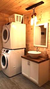 y baño con lavabo y lavadora. en Chalet bois rond aux paysages uniques avec Spa !, en Lac-aux-Sables