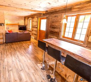 una sala de estar con un bar en una cabaña de madera en Chalet bois rond aux paysages uniques avec Spa !, en Lac-aux-Sables