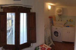 eine Waschküche mit einem Fenster und einer Waschmaschine in der Unterkunft Casa Torre con terrazza panoramica in Futani