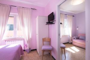 a bedroom with purple walls and a bed and a couch at Green Quiet Affittacamere in Pignone