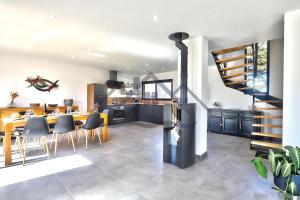 eine Küche und ein Esszimmer mit Tisch und Stühlen in der Unterkunft LocaLise - M68 - An Aod Melen - Maison neuve à 50m de la plage et à quelques pas du centre et des plages - Draps inclus - Wifi inclus in Le Guilvinec