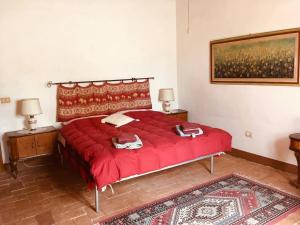 a bedroom with a red bed with two towels on it at Agriturismo Bethsaid in Fauglia