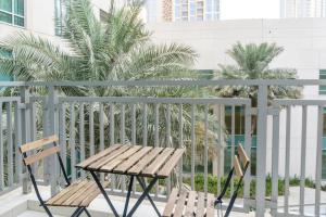 2 sedie e un tavolo sul balcone con palme di The Lofts, Downtown Dubai - Bright One Bedroom a Dubai