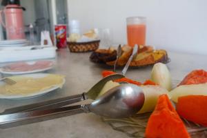 康塞桑達巴拉的住宿－太陽花旅館，一张桌子,上面有汤匙和一些水果
