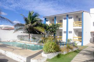Villa con piscina frente a un edificio en Pousada Solar das Flores en Conceição da Barra