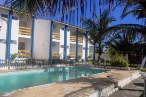 a swimming pool in front of a building at Pousada Solar das Flores in Conceição da Barra