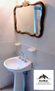łazienka z umywalką i lustrem na ścianie w obiekcie Cabaña con Vista al Lago en Barrio Melipal - Bariloche w mieście Bariloche