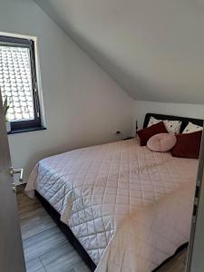 Schlafzimmer mit einem großen weißen Bett und einem Fenster in der Unterkunft Apartmaji Tisa in Žana in Rovte