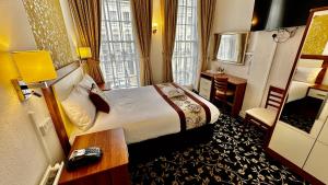 a hotel room with a bed and a desk and a bedroom at Andorra Guest Accommodation in Brighton & Hove