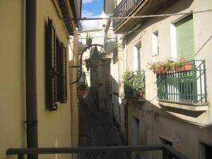 um beco com edifícios com flores nas varandas em Appartamento Bilocale in centro storico Calopezzati em Calopezzati