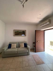 uma sala de estar com um sofá e uma porta em Appartamento Bilocale in centro storico Calopezzati em Calopezzati
