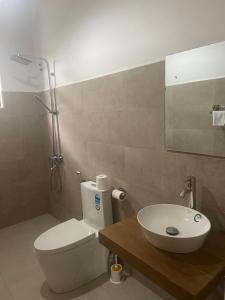 a bathroom with a white toilet and a sink at The Pearl in Marawila +14 photos