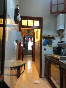 cocina con mesa y puerta a una habitación en Appartement meublé 5 personnes en plein centre ville, en Rabat