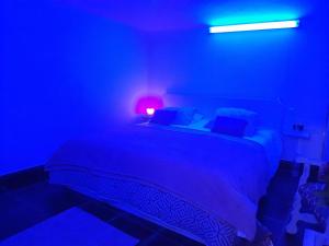a dark room with a bed with a blue light at Mi Placer in Valverde