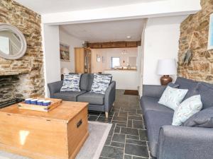 a living room with a couch and a table at Bumblebee Cottage in Salcombe