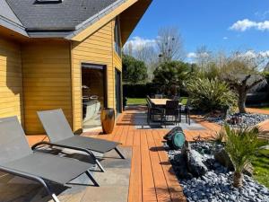 eine Terrasse mit Stühlen und einem Tisch auf einem Haus in der Unterkunft Les Pins Noirs in Le Bû-sur-Rouvres