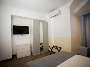 1 dormitorio con cama, espejo y TV en Anastasio Vatican Rooms G H en Roma