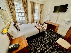 Habitación de hotel con cama y escritorio en Andorra Guest Accommodation, en Brighton & Hove