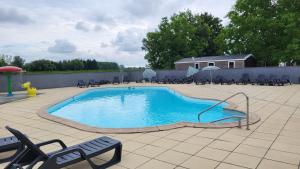 a large swimming pool with chairs and a fence at Anne Marie Touzani in Boofzheim