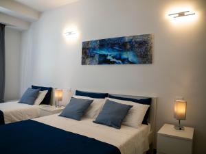 a bedroom with two beds and a painting on the wall at Anastasio Vatican Rooms G H in Rome