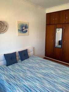 een slaapkamer met een groot bed met blauwe kussens bij Almograve - Praias in Almograve