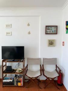 een woonkamer met 2 stoelen en een televisie bij Almograve - Praias in Almograve