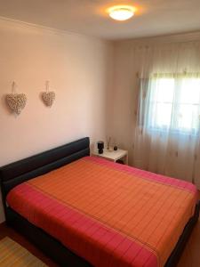 een slaapkamer met een groot bed en een rode deken bij Almograve - Praias in Almograve