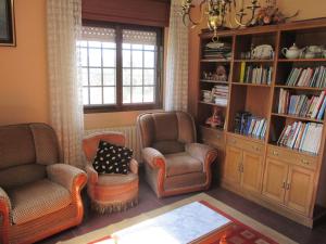 DornaにあるHotel Cholaのリビングルーム(椅子2脚、本棚付)