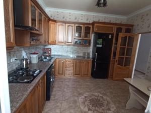 a kitchen with wooden cabinets and a black refrigerator at Green Garden in Ijevan