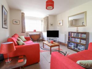 a living room with two red couches and a tv at Minffordd in Llangollen