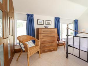 a bedroom with a bed and a dresser and a chair at Minffordd in Llangollen