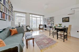 a living room with a couch and a table at Large one bedroom flat with balcony close to the City by UnderTheDoormat in London