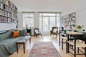 a living room with a couch and a table at Large one bedroom flat with balcony close to the City by UnderTheDoormat in London